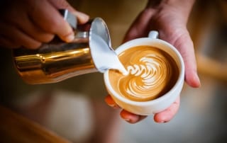 Photo of a Barista Pouring a Latte at One of the Best Harrisburg Coffee Shops.